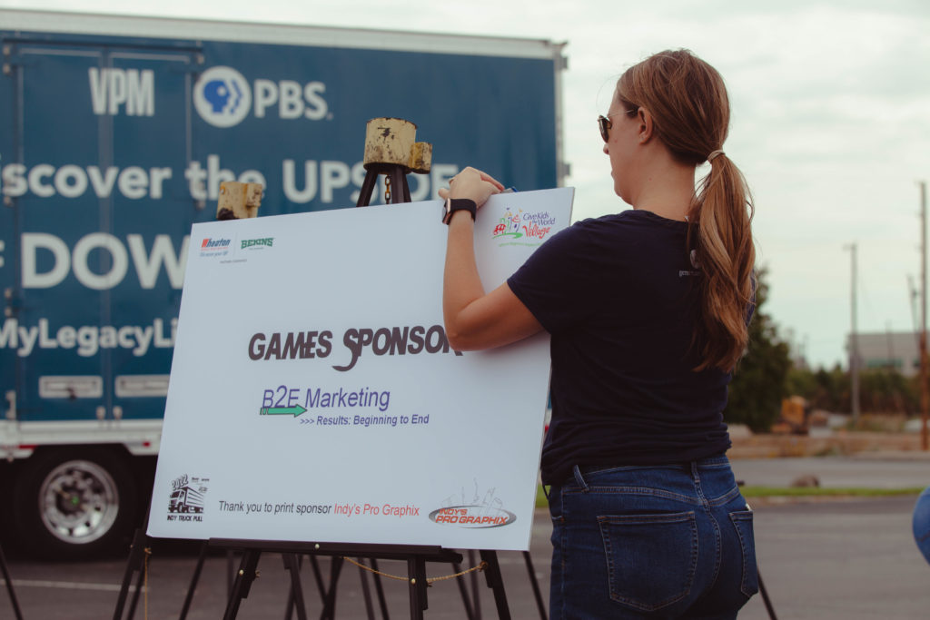 Un bénévole installe des pancartes de sponsors lors d'une collecte de fonds pour camions